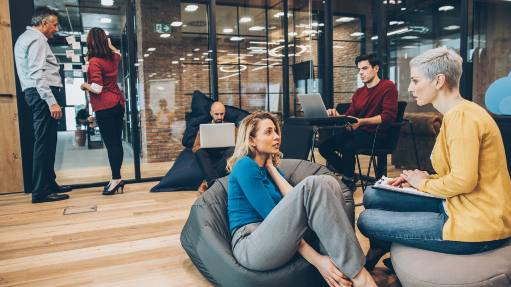 Coworkers working on beanbags, chairs and standing.