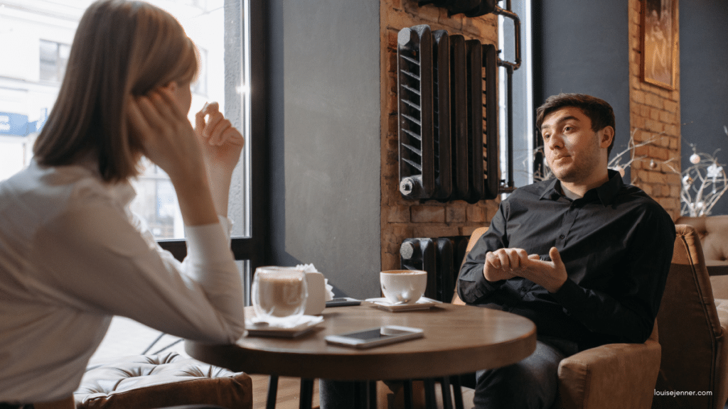 Two people having an informal yet professional conversation over coffee.